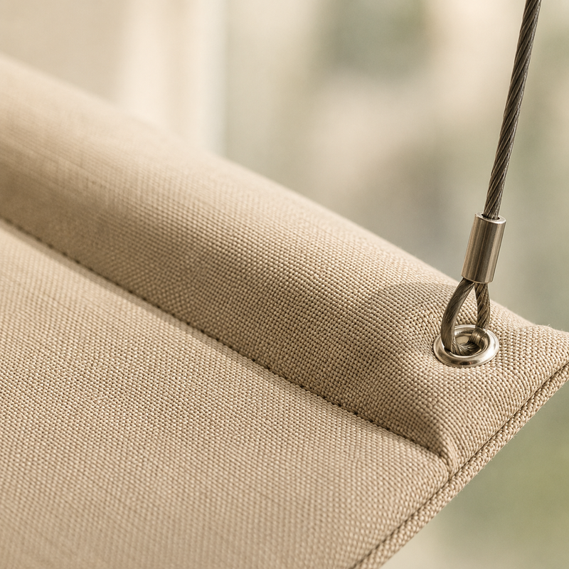 Gros plan sur le tissu beige et l'ourlet matelassé du hamac